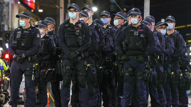 Police face off against anti-lockdown protesters outside Flinders Street station. Picture: Ian Currie