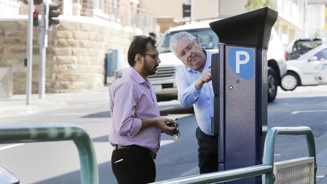 A Hobart City Council employee helps a motorist figure out one of the new parking meters. Picture: MATHEW FARRELL