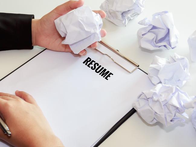 CAREERS: Hands of woman crumple sheets of Resume at the desk, mistake resume.