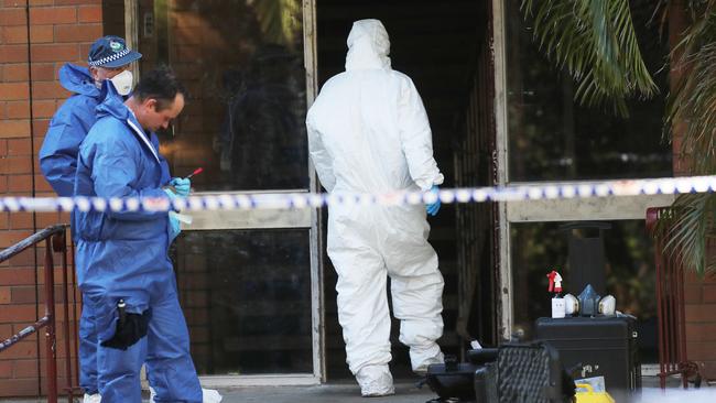 Forensic experts at the entrance to the Hamilton South unit block where Anthony Nugent was shot after answering the front door to his first floor unit. Picture by Peter Lorimer.