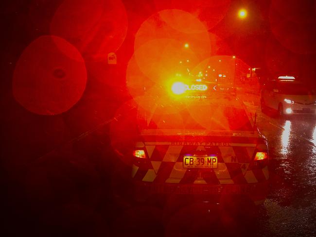 A police car blocks a flooded road after heavy rain overnight caused flooding around Manly and the Manly dam to spill over.Photo:  Chris McKeen