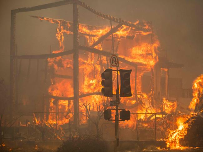 LOS ANGELES, CALIFORNIA - JANUARY 8: Flames from the Palisades Fire burn a building on Sunset Boulevard amid a powerful windstorm on January 8, 2025 in the Pacific Palisades neighborhood of Los Angeles, California. Fueled by intense Santa Ana Winds, the Palisades Fire has grown to overÂ 15,000Â acres and 30,000 people have been ordered to evacuate while a second major fire continues to burn near Eaton Canyon in Altadena.   Apu Gomes/Getty Images/AFP (Photo by Apu Gomes / GETTY IMAGES NORTH AMERICA / Getty Images via AFP)