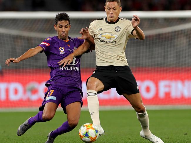 Manchester United midfielder Nemanja Matic is challenged by Perth Glory’s Juande. Picture: AAP