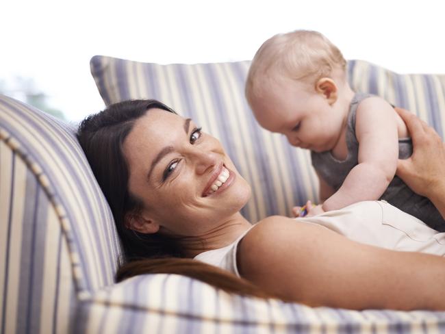 Portrait of an attractive young woman and her baby boy lying on the sofa