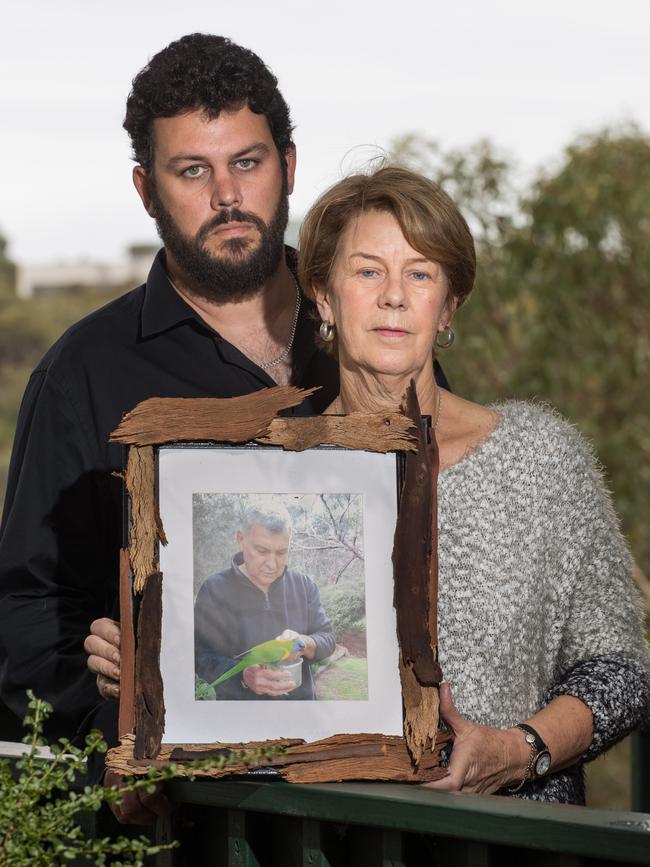 Clive and Barb Spriggs in their family home in Bellevue Heights, with a photo of father and husband Bob, who was mistreated at Oakden. Picture: Matt Loxton