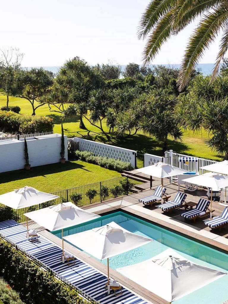 The pool is lined with blue-and-white striped lounges where staff ferry cocktails to guests. Picture: Halcyon House