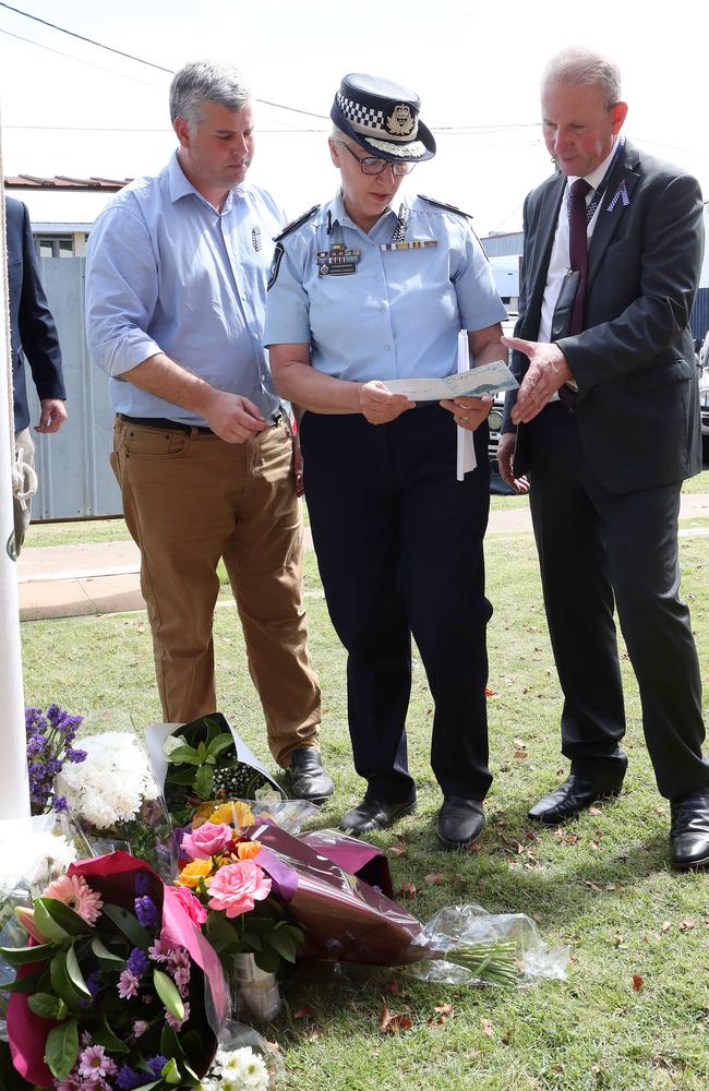 Police Minister Mark Ryan, Police Commissioner Katarina Carroll and Police Union President Ian leavers, look at tributes left at Chinchilla Police Station. Picture: Liam Kidston