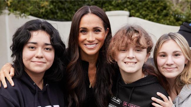 The Duchess of Sussex looks radiant as she poses with teenagers from the AHA! Santa Barbara youth group.