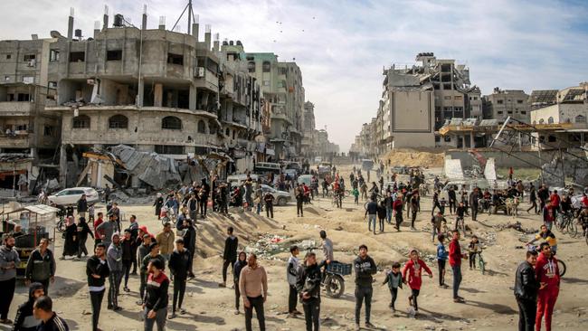 Palestinians gather in a street as humanitarian aid is airdropped. Picture: AFP