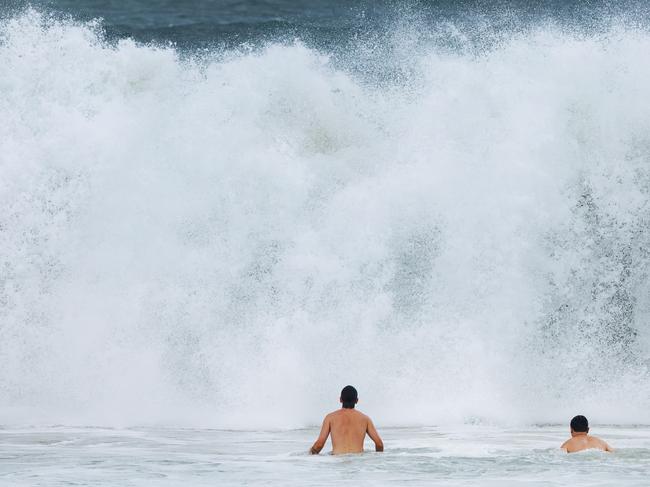 Beachgoers dwarfed by whitewater as big swells hit Mooloolaba on Sunday. Picture: Lachie Millard