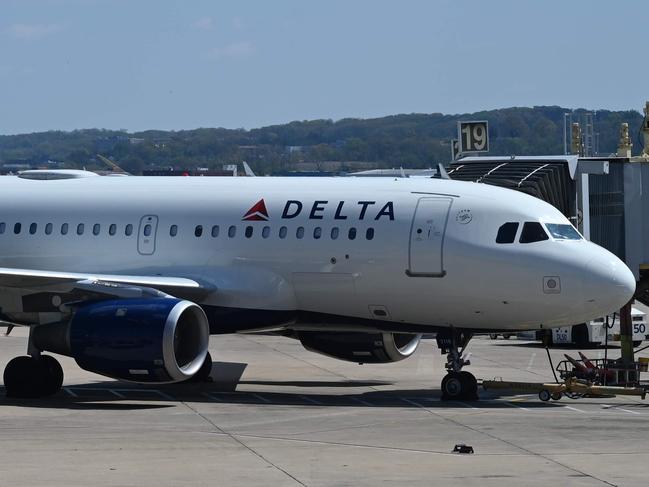 (FILES) In this file photo a Delta Airlines plane is seen at gate at Washington National Airport (DCA) on April 11, 2020 in Arlington, Virginia. - Five more US air carriers including Delta Air Lines and United Airlines will take out loans under the CARES Act stimulus package, Treasury Secretary Steven Mnuchin said on July 7, 2020. The decision means most major US air carriers have agreed to accept financing from the $2.2 trillion measure passed in late March to blunt the impact of the coronavirus pandemic. (Photo by Daniel SLIM / AFP)