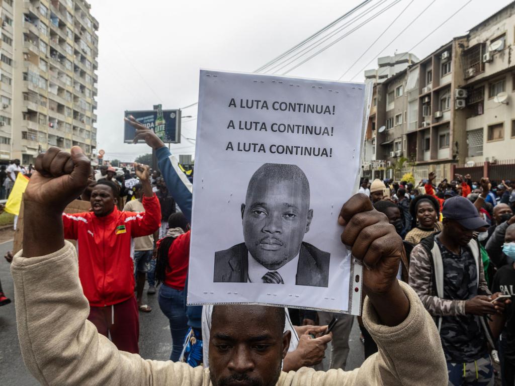 A supporter of the Optimist Party holds a photograph of the slain lawyer Elvino Dias that carries a the message "A Luta Continua" (The Fight Carries On) during a strike called in Maputo this week.