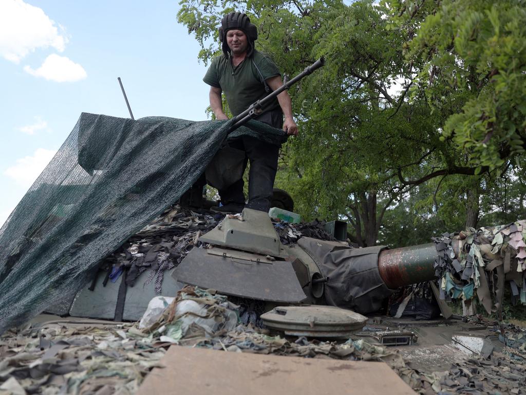 A Ukrainian serviceman covers the turret of an tank in the eastern Ukrainian region of Donbas amid "catastrophic destruction" in Lysychansk. Picture: AFP