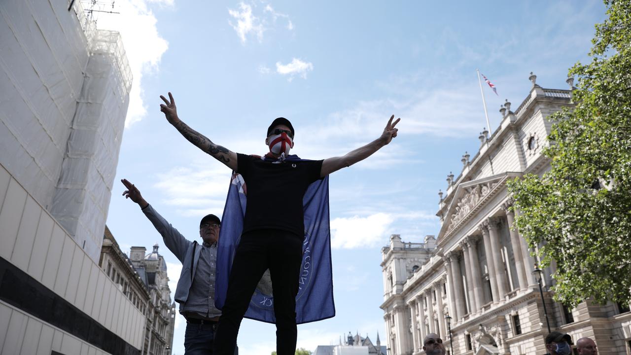 A protester wearing a St George's Cross face mask climbs on a barrier. Picture: Dan Kitwood/Getty Images