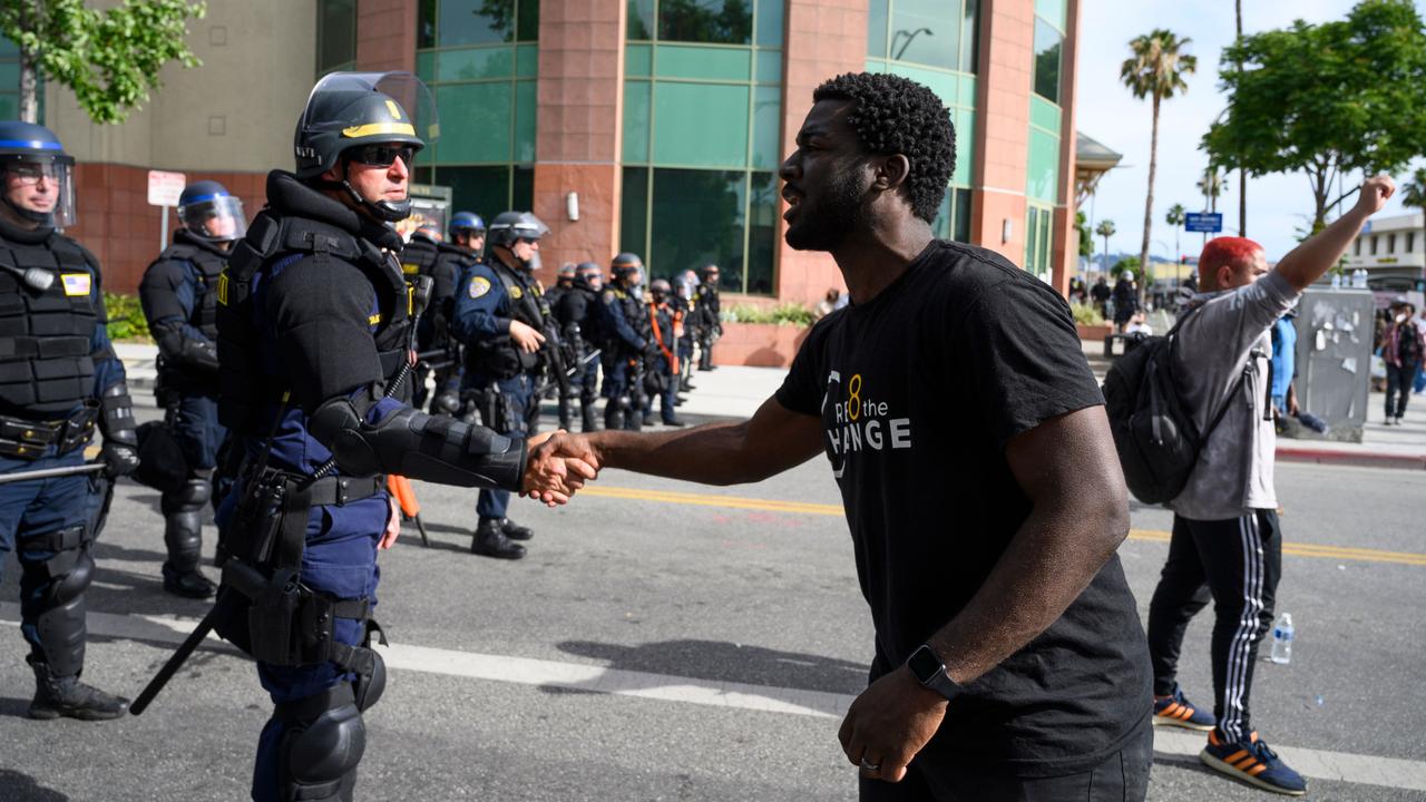 There have been moments of unity such as protester Kevin Welbeck of Cre8 The Change shaking hands with a Highway Patrol officer on June 1 in Los Angeles, California. Picture: Robyn Beck/AFP