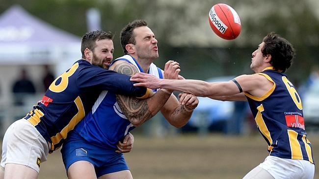 Sunbury Kangaroos’ John Baker is crunched between Rupertswood opponents Niall McGovern and Austin Cicero on Saturday. Photo: Angie Basdekis.