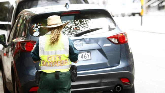 A Sydney Council ranger checks a car on Liverpool Street. Picture: John Appleyard