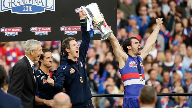 John Schultz and Luke Beveridge watch Bob Murphy and Easton Wood hold the cup aloft. Picture: Colleen Petch