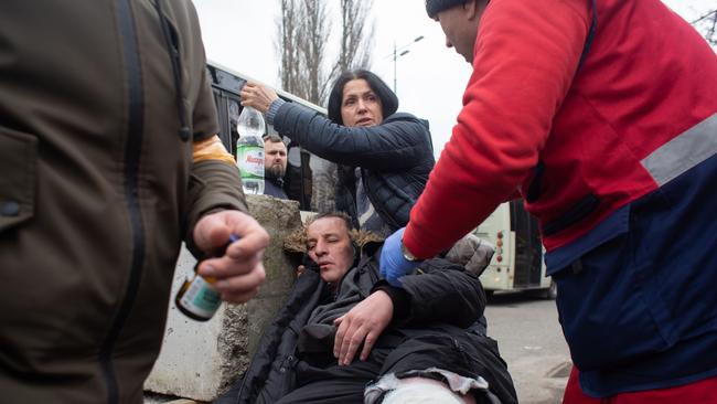 Yuriy, who was shot in the leg while evacuating civilians from the shelled city of Irpin receives first aid on Sunday. Picture: Getty Images