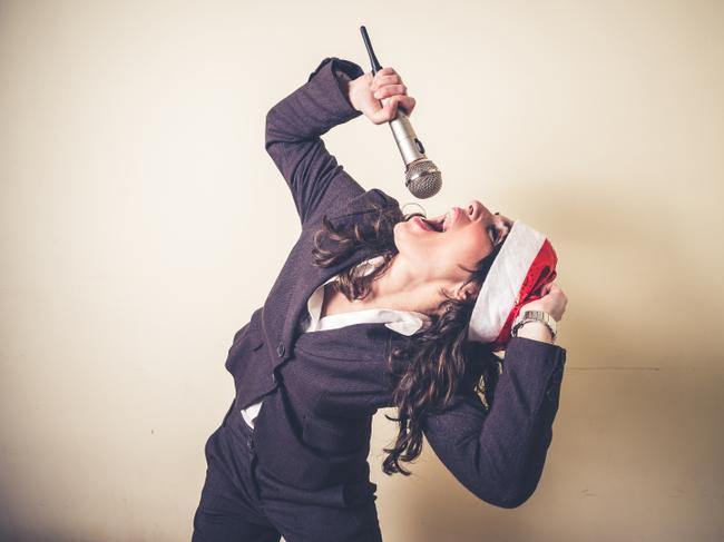 RendezView. Christmas businesswoman singing with microphone on white background. (Pic: iStock)