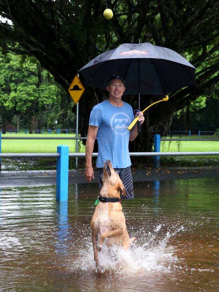 Muttley the dog enjoys running through the puddles at Goomboora Park with owner Simon Boyd. PICTURE: ANNA ROGERS