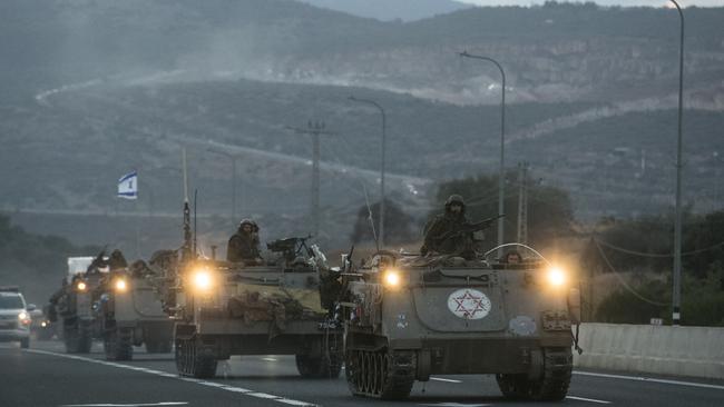 Israeli armored personnel carriers move in formation near the border with Lebanon.