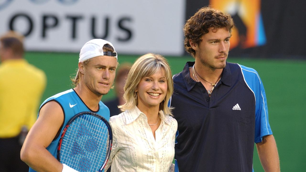 Newton-John with Australia’s Lleyton Hewitt, left, and Russia’s Marat Safin in the 2005 Australian Open Mens final.