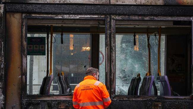 A worker assess the damage to a fire-damaged Luas tram on O'Connell Street in Dublin.