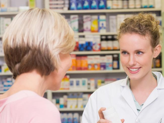 SA WEEKEND - April 15 - Healthy 100 tips - Pharmacist showingmedicine jar - Stock image SA WEEKEND - April 15 - Healthy 100 tips - Pharmacist showing medicine jar - Stock image. Pharmacist and sick customer speaking in the pharmacy