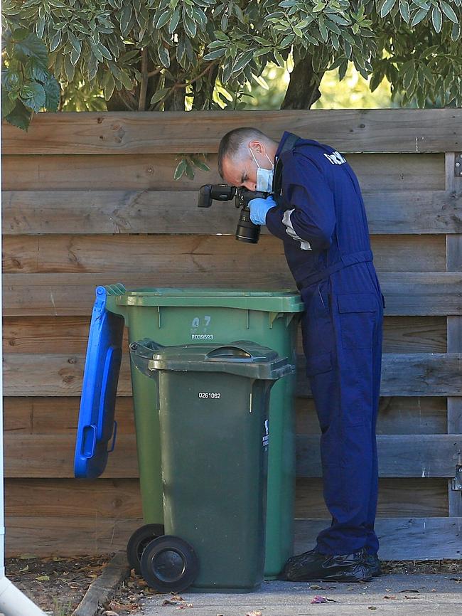 A forensic detective photographs the contents of a garbage bin at the home. Picture: Mark Stewart