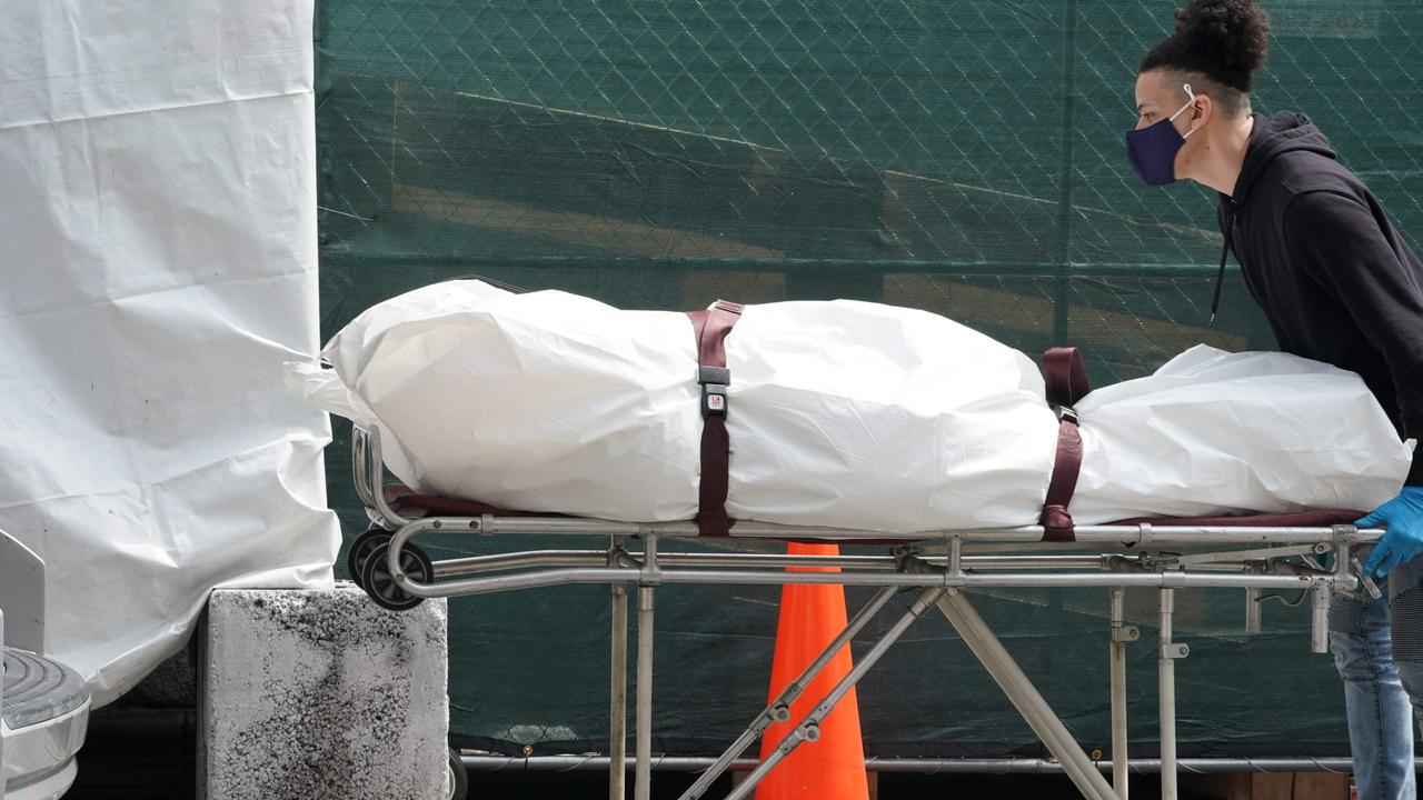 A body is moved from a refrigeration truck serving as a temporary morgue to a vehicle at the Brooklyn Hospital Center, in the Borough of Brooklyn on April 8, 2020 in New York. Picture: Bryan R. Smith / AFP.