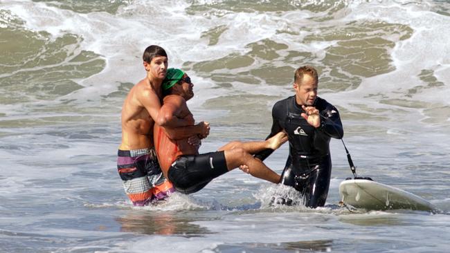 His rescue ... two men carry Steven Robles off southern California’s Manhattan Beach. PictureL goofyfootphotography.com, Laura Joyce