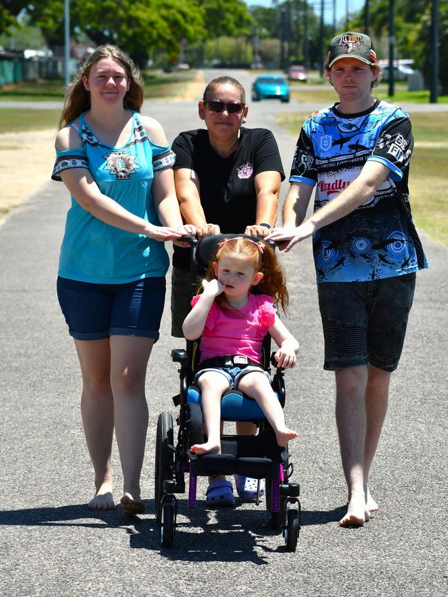 Jo Costin, who is Elora’s grandmother, mother Alisa Jakavicius and father Liam Bremen wheel Elora Bremen along Cooper Street in Ingham. Picture: Cameron Bates