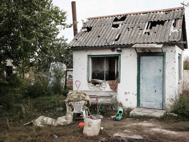 Stuffed Russian army uniforms in front of a damaged building at an industrial chicken farm, near which the Russian forces were dug in, near a suspected mass grave in Kozacha Lopan.