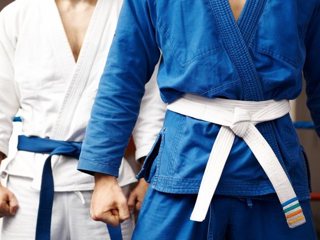 Two judo fighters stand their ground with fists ready to fight - cropped