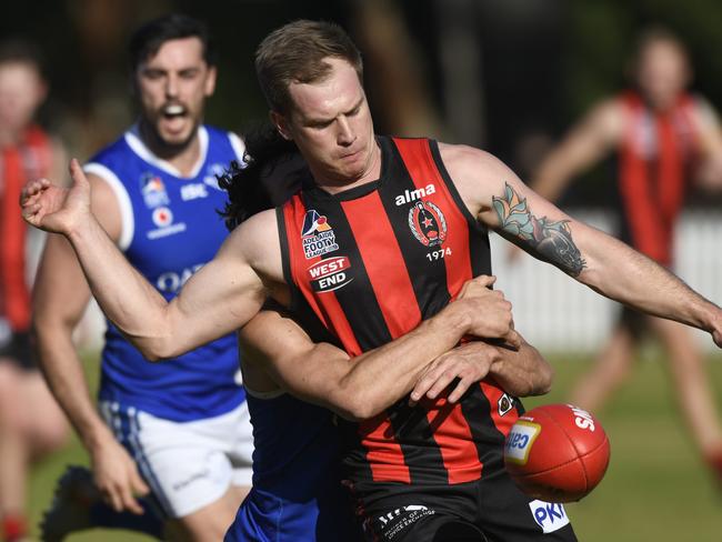 JULY 25, 2020:  Adelaide Footy League division one match between Rostrevor Old Collegians and St Peter's Old Collegians at Campbelltown Memorial Oval. ROCÃs #12 Dylan Reinbrecht is tackled as he takes a kick. Picture: Naomi Jellicoe