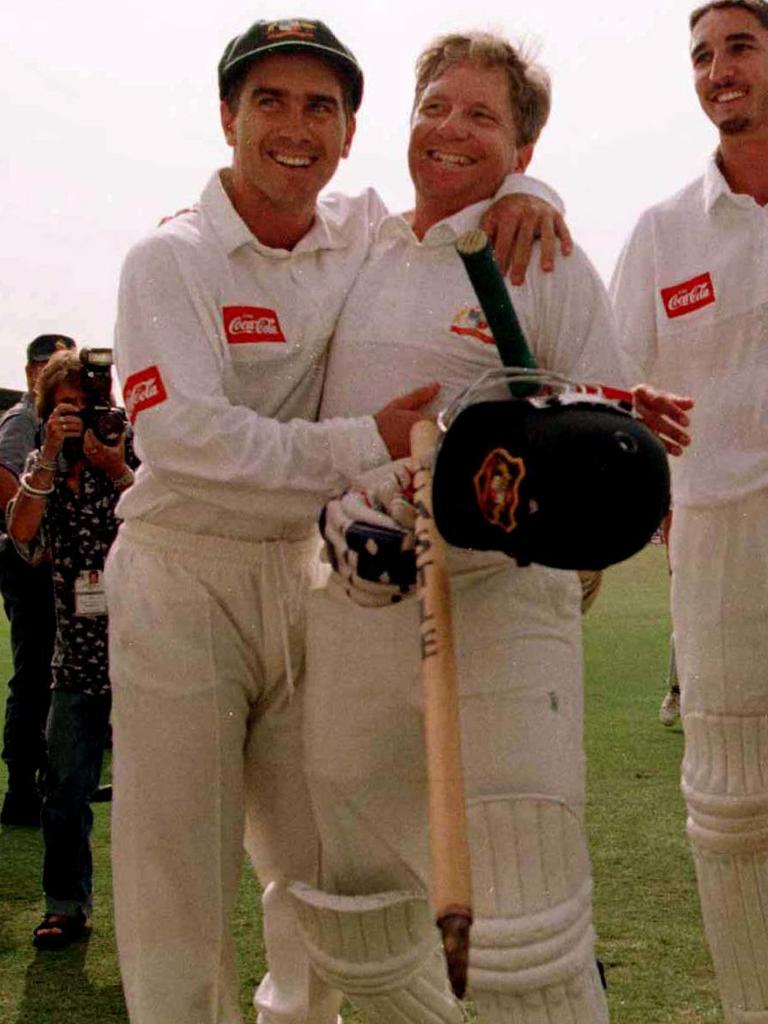 Justin Langer (L) hugs Ian Healy.