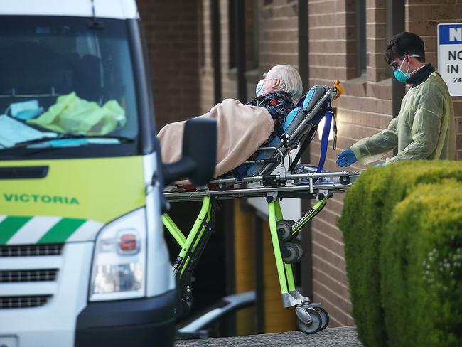 Menarock LIFE Aged Care in Essendon, is part of an outbreak of coronavirus infections at multiple aged care homes across Melbourne. A resident leaves in a patient transport ambulance. Picture : Ian Currie