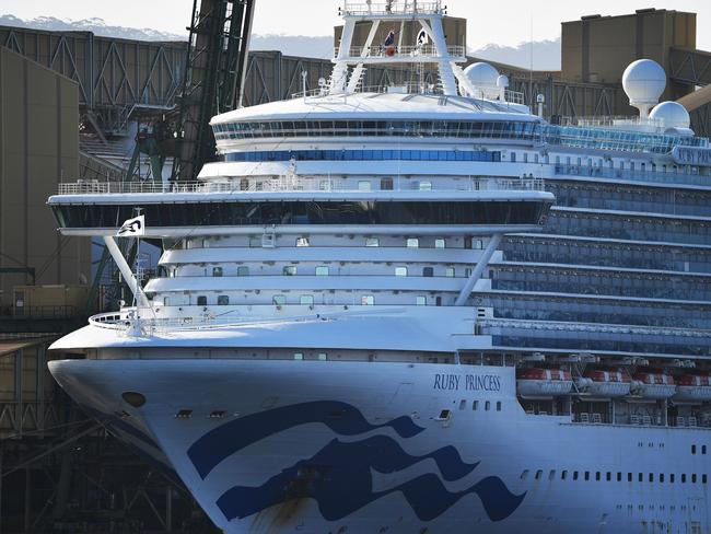 Cruise liner Ruby Princess docks at the harbour in Port Kembla, some 80 kilometres south of Sydney on April 12, 2020. - The Ruby Princess berthed after weeks stranded at sea to allow doctors to assess sick crew members and take the most serious cases ashore for medical treatment. (Photo by Saeed KHAN / AFP)