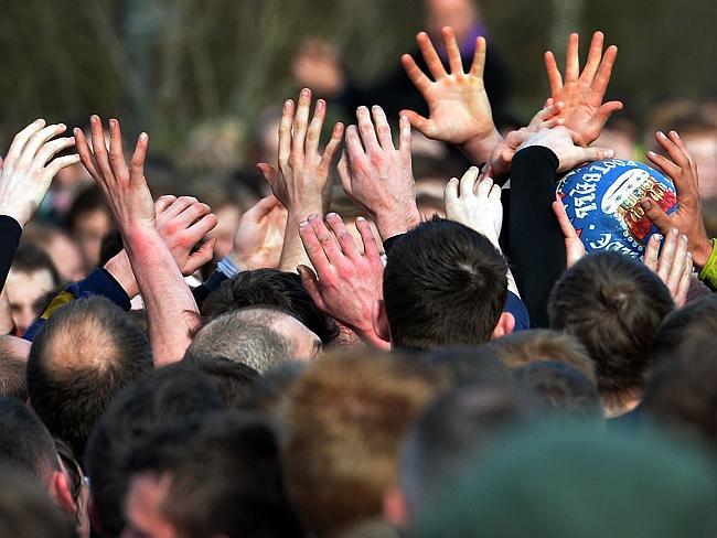 Hands reach for the ball as the game moves through the town.  