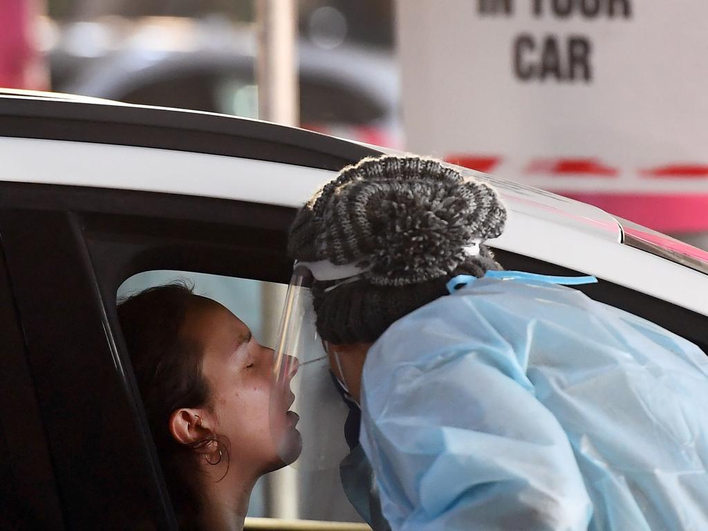 Medical workers staff a drive-through COVID-19 testing site located in a shopping centre carpark in Melbourne today. Picture: William WEST / AFP.