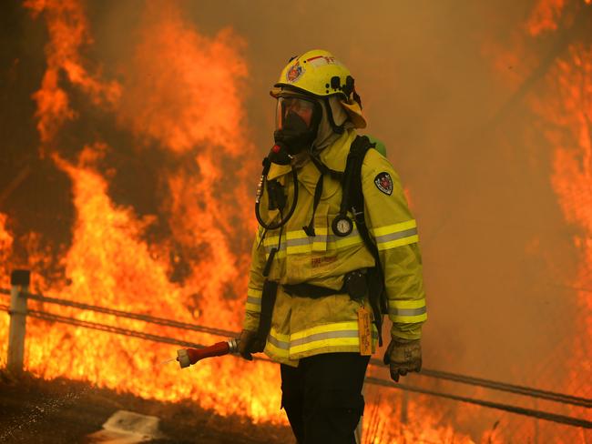 12/11/2019. NSW Fire and Rescue battling a blaze on the Pacific Highway which was closed south of Taree. Wild bushfires have ravaged over 1,000,000 hectares of the midcoast of NSW and Queensland since fires began on Friday. Jane Dempster/The Australian.