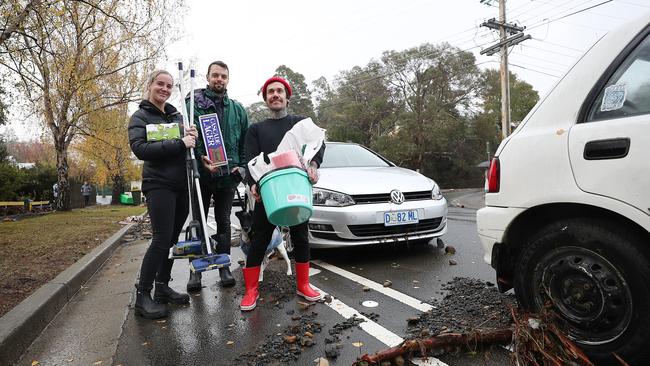 South Hobart residents Casey Morgan, left, Jason Scarr and Patrick Barnes on their way home in Degraves Street to clean up. Picture: SAM ROSEWARNE