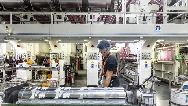 An operator sets up a printing machine at an Amcor packaging plant. Picture: Bloomberg via Getty Images