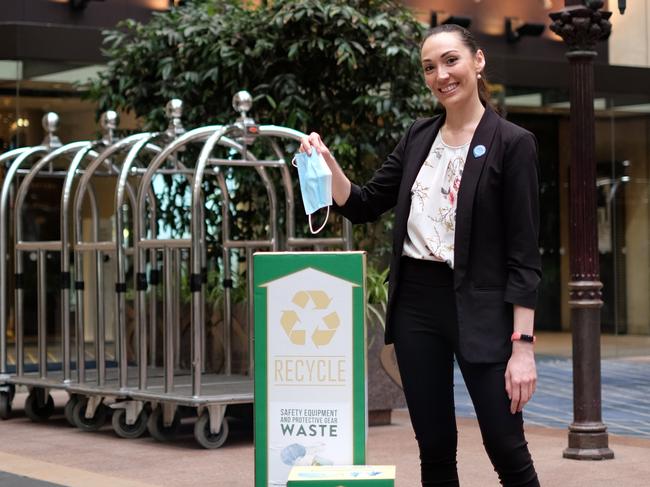 Johanna Bouniol, Environment Manager at Melbourne's Sofitel hotel, disposes of a mask in a TerraCycle collection box.