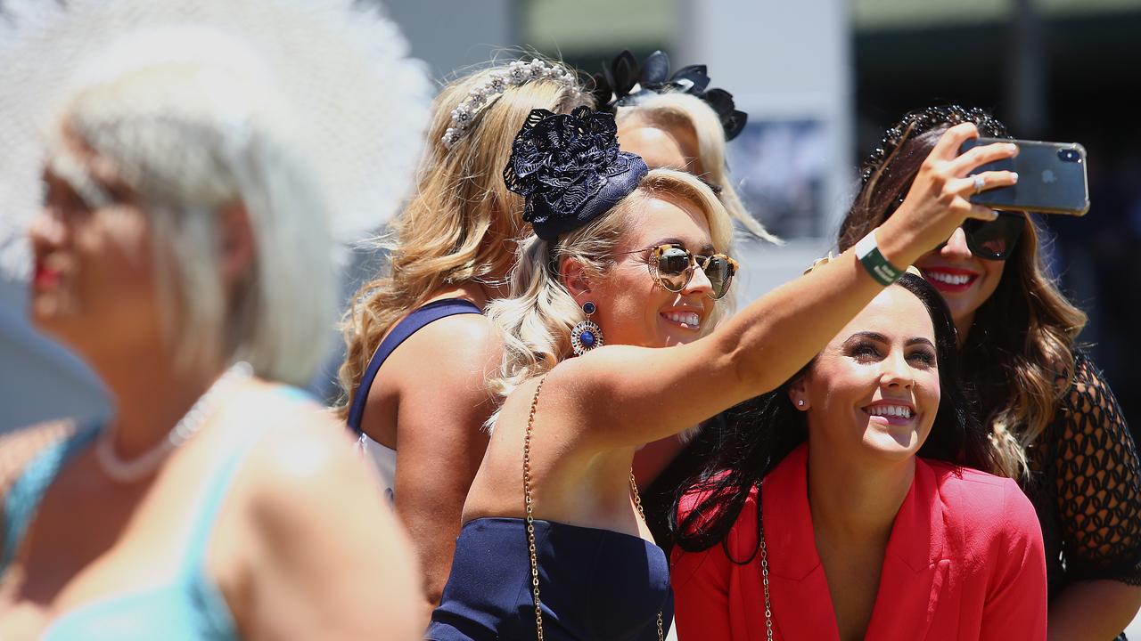 Race fans take photos during Gold Coast Magic Millions Race Day at the Gold Coast Turf Club. Photo: Jono Searle