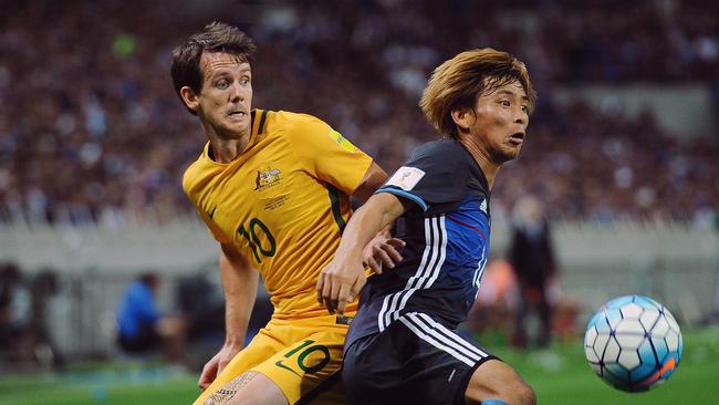 Robbie Kruse competes against Takashi Inui of Japan.