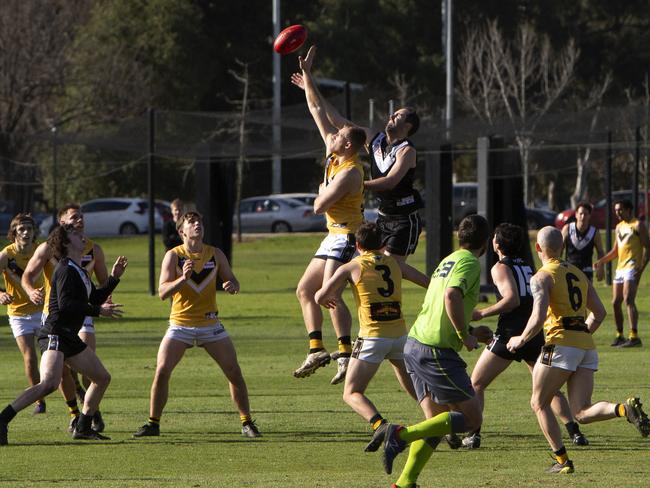 Bombers Player Hayden Kanisauskas tapping the ball with Tom Bateman behind. Adelaide Footy League division one match between The Blacks Adelaide University Football Club Coach (Ben Watkins) and Brighton Bombers Football (Coach Joel Tucker) at University Oval (Park 12), Adelaide. Photographer Emma Brasier