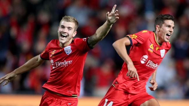 Adelaide United’s Riley McGree and George Blackwood celebrate a goal against Central Coast Mariners at Coopers Stadium in February. (AAP Image/Kelly Barnes)