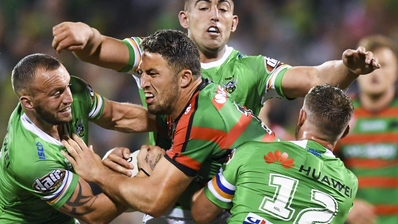 Josh Hodgson of the Raiders (left) tackles Sam Burgess of the Rabbitohs